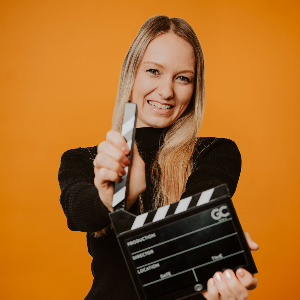 Filmklappe vor orangefarbenem Hintergrund  goldencutmedia Filmproduktion