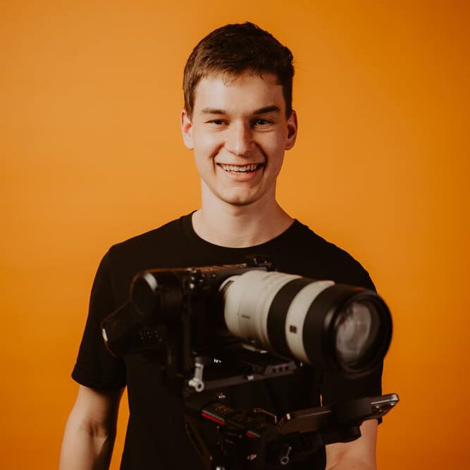 Kameramann mit Teleobjektiv im Studio  goldencutmedia Filmproduktion
